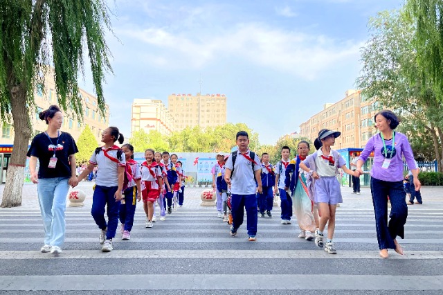 01 臨澤縣城關小學“紅燭先鋒”護學崗教師護送學生放學。謝靜 攝.jpg