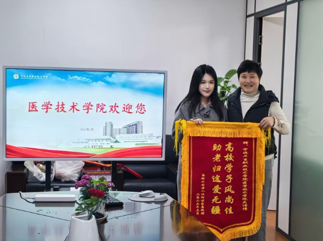 獲助老人家屬汪女士將錦旗送到寧波衛生職院學生吳倩倩手中 學校供圖.jpg