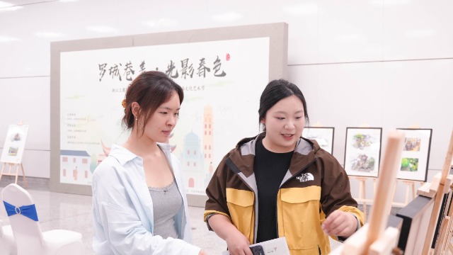 浙江工商職院學生在“羅城巷美·光影春色”主題展介紹作品 學校供圖.jpg
