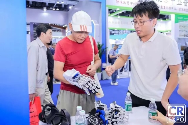 于金須在博覽會上向來賓介紹手部康復機器人 學校供圖.jpg 于金須在博覽會上向來賓介紹手部康復機器人 學校供圖.jpg
